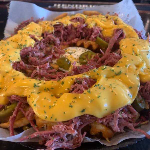 Waffle fries topped with shredded corned beef, melted cheese, jalapeños, and a dollop of sour cream.